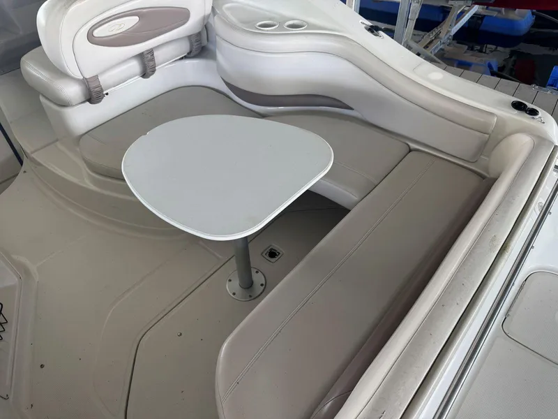 Slide: The Image of Interior seating area of a 2000 Regal Commodore 2460 boat with a small table. - 9