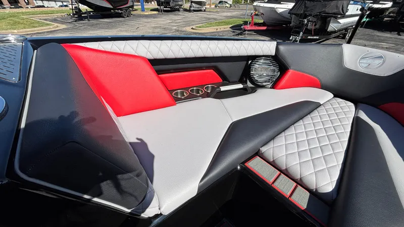 Slide: The Image of 2026 Tigé Z5 boat interior with red and gray quilted seating and cup holders. - 15