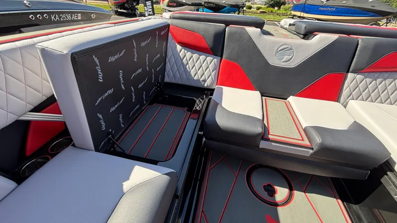 Slide: The Image of 2026 Tigé Z5 boat interior with red and gray seating, diamond stitching, and storage compartment. - 29