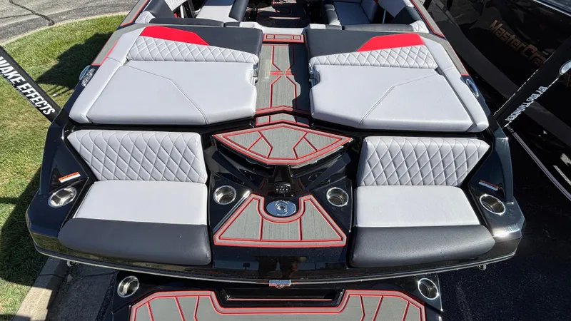 Slide: The Image of 2026 Tigé Z5 boat interior with gray and red upholstery, featuring quilted seating and cup holders. - 3