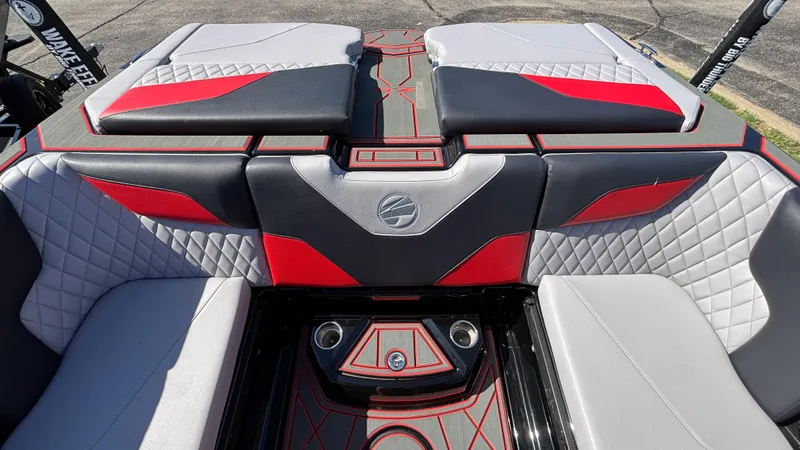 Slide: The Image of 2026 Tigé Z5 boat interior with red and gray quilted seating and cup holders. - 32