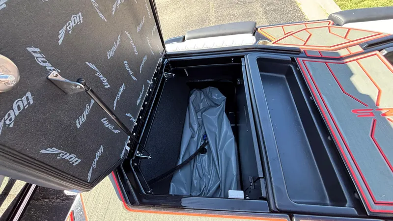 Slide: The Image of Open storage compartment in 2026 Tigé Z5 boat, featuring branded interior lining. - 35