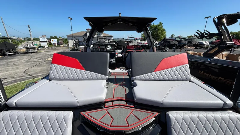 Slide: The Image of 2026 Tigé Z5 boat interior with gray and red seating, parked outdoors. - 41