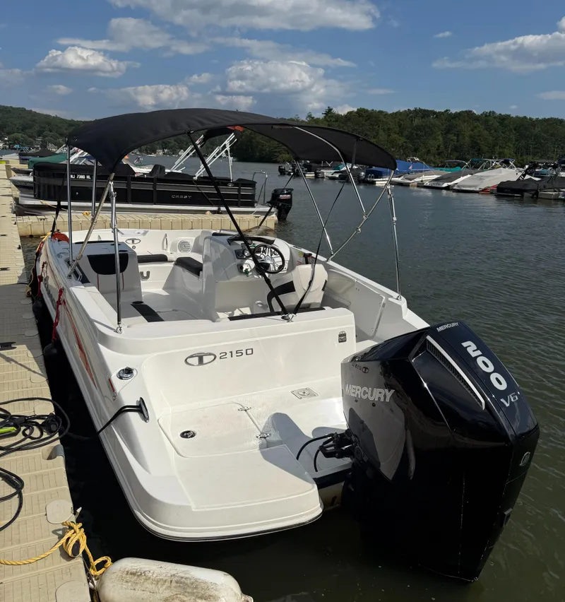 Slide: The Image of 2023 Tahoe 2150 boat docked, featuring a Mercury 200 V6 engine, under a clear sky. - 3