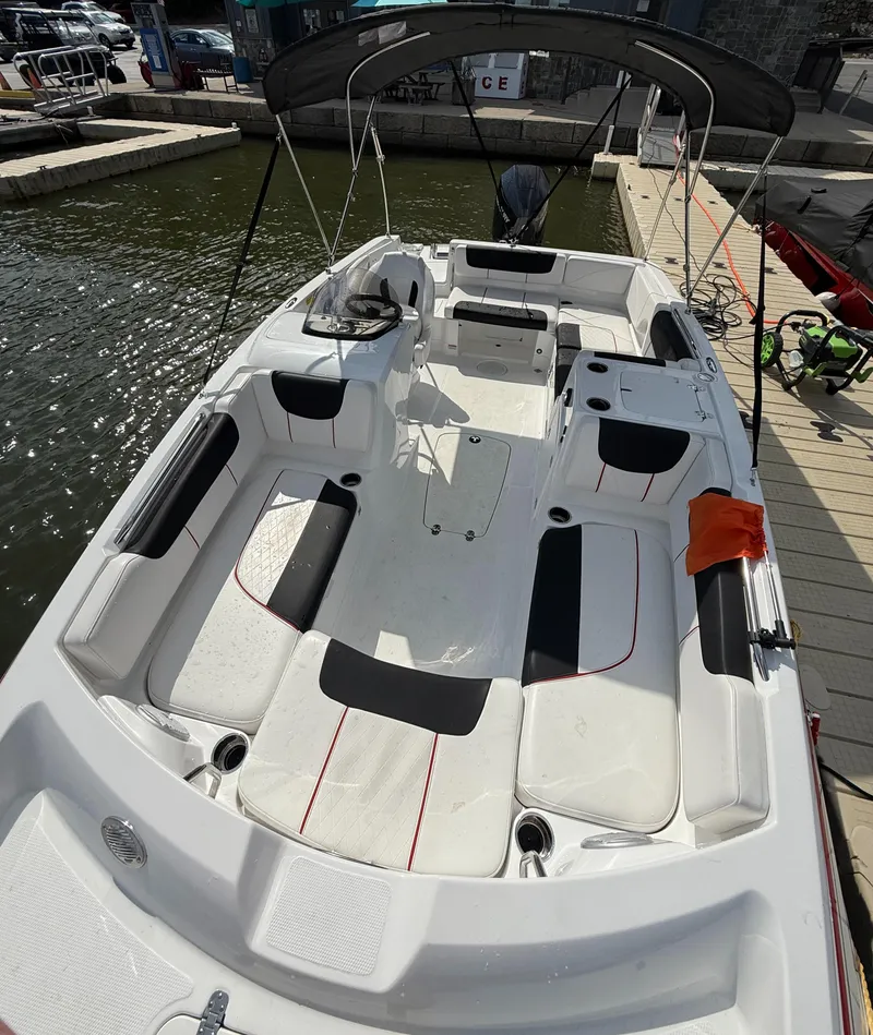 Slide: The Image of 2023 Tahoe 2150 boat with spacious seating, docked by the water. - 4