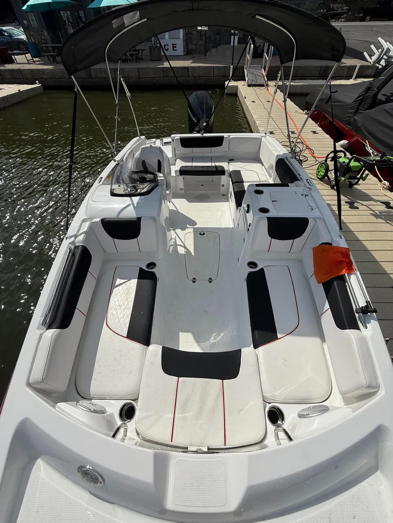 Slide: The Image of 2023 Tahoe 2150 boat interior with seating, docked at marina. - 7