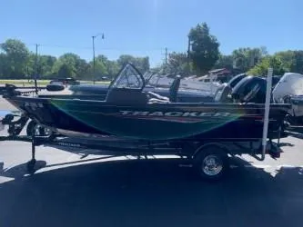 Slide: The Image of 2022 Tracker Pro Guide V-16 WT boat on trailer, parked outdoors. - 2