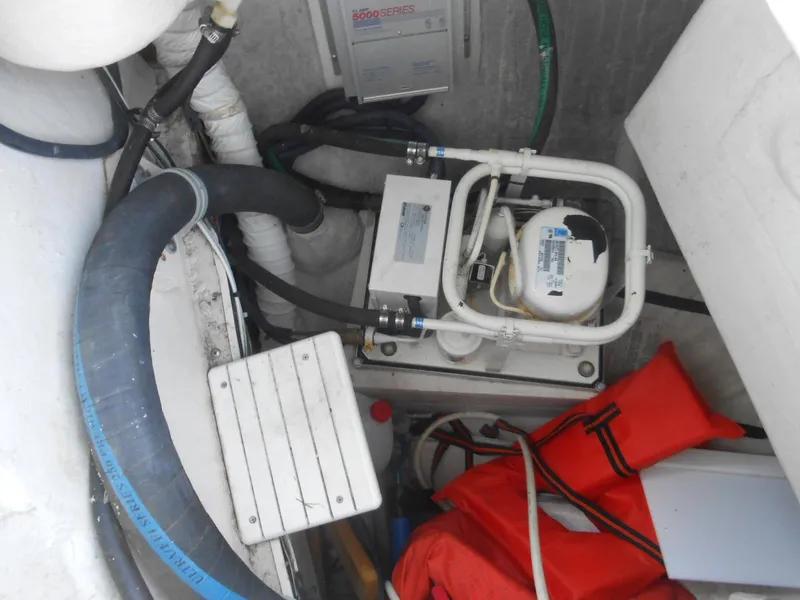 Slide: The Image of Boat engine compartment with hoses, equipment, and life jackets in a 2004 Catalina 387. - 11