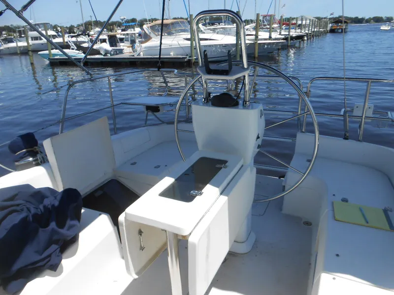 Slide: The Image of 2004 Catalina 387 sailboat cockpit with steering wheel, docked at marina. - 12