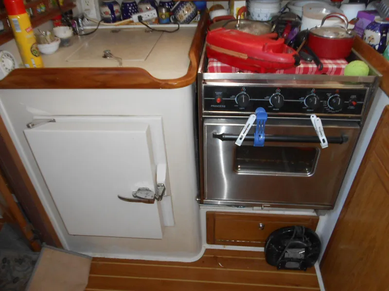 Slide: The Image of Compact kitchen area in a 2004 Catalina 387 sailboat with stove and storage. - 17