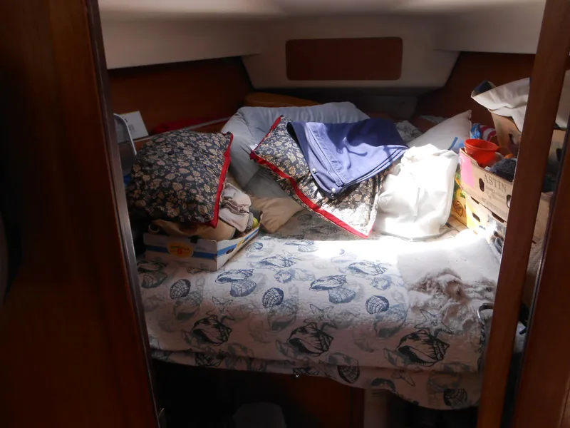 Slide: The Image of Cozy cabin interior of 2004 Catalina 387 sailboat with bed and assorted items. - 22