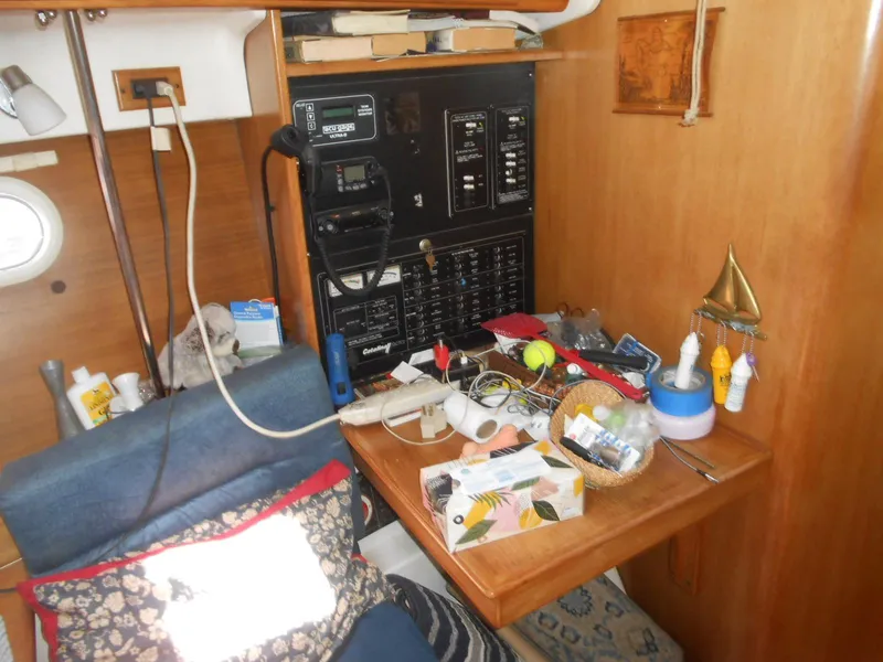 Slide: The Image of Cozy Catalina 387 sailboat interior with navigation panel and cluttered desk, 2004 model. - 24