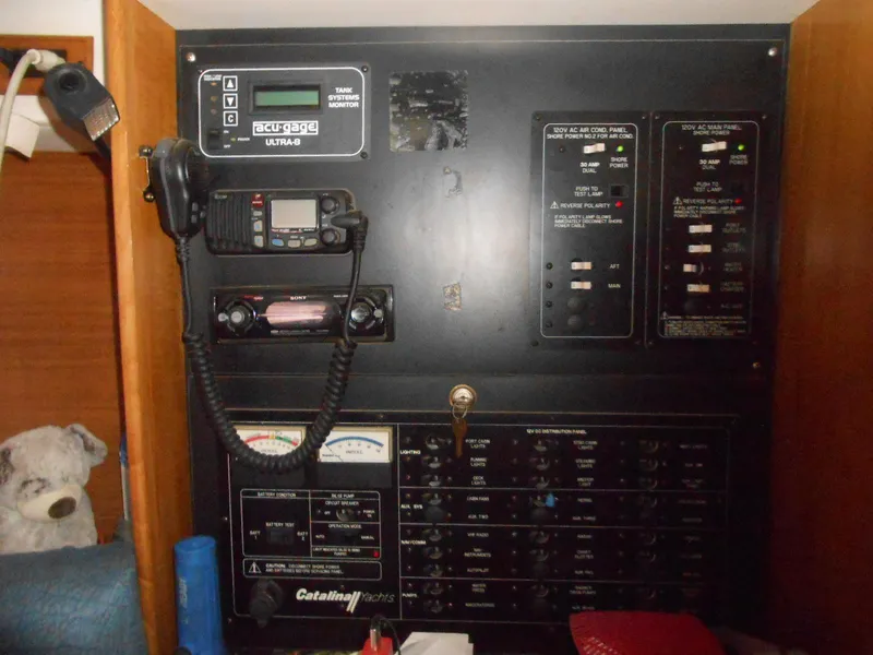Slide: The Image of Electrical control panel inside a 2004 Catalina 387 yacht, featuring various switches and gauges. - 26