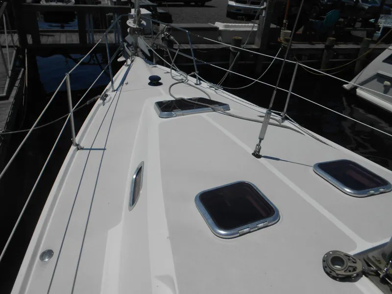 Slide: The Image of 2004 Catalina 387 sailboat deck with hatches and rigging at a marina. - 37