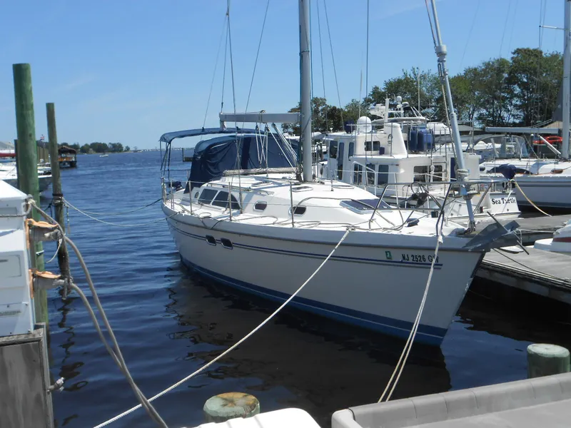 Slide: The Image of 2004 Catalina 387 sailboat docked at marina, calm water, clear sky. - 4