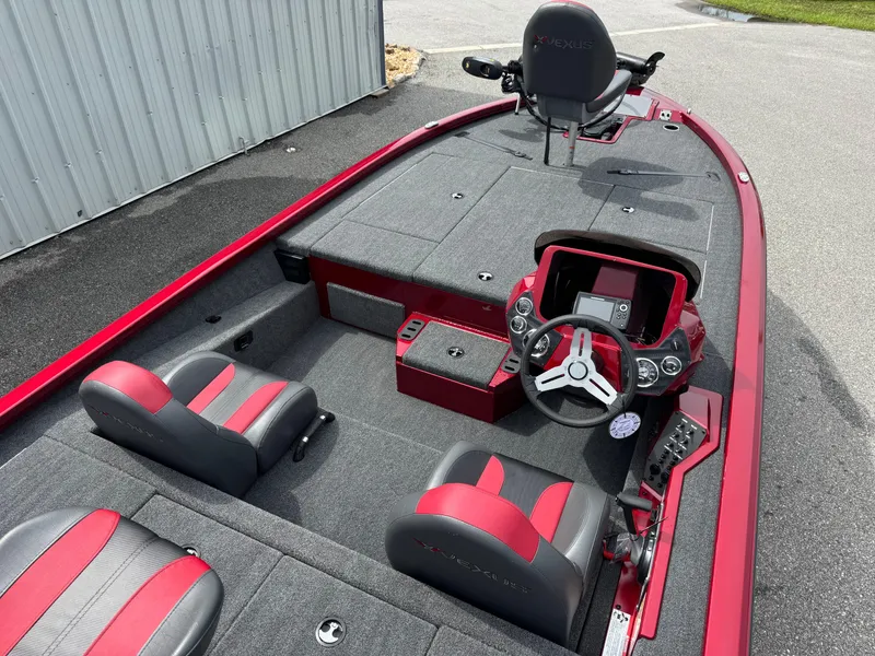 Slide: The Image of 2026 Vexus AVX1880 boat interior with red and gray seating, steering console, and fishing deck. - 16