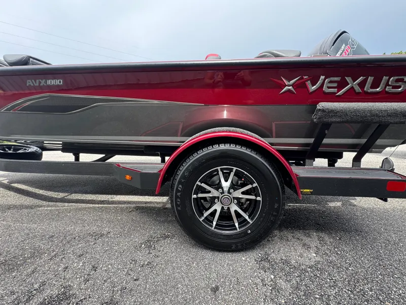 Slide: The Image of 2026 Vexus AVX1880 boat on trailer, red and gray design, close-up view. - 5