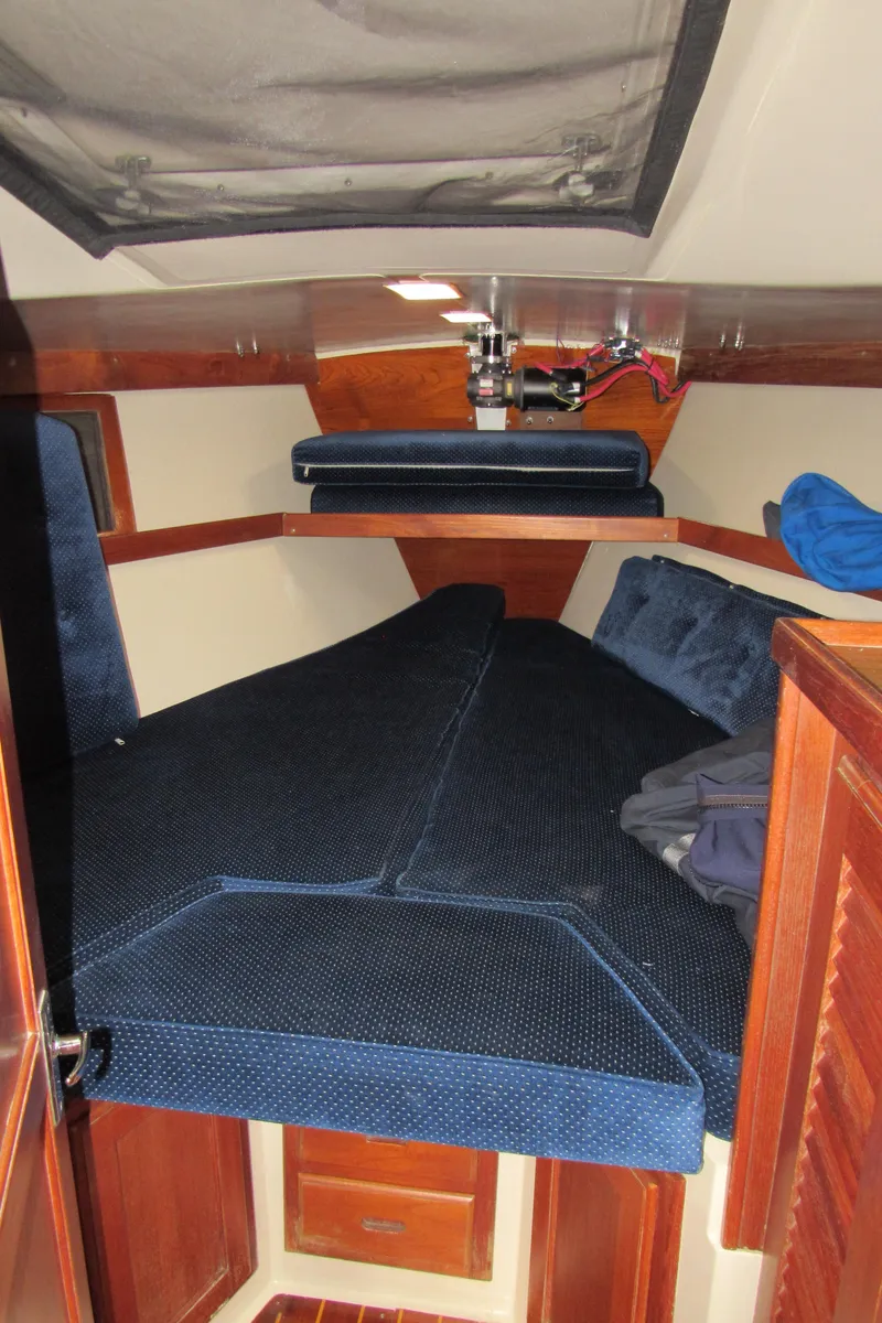 Slide: The Image of 1986 Catalina 36 sailboat interior cabin with blue cushions and wooden accents. - 11
