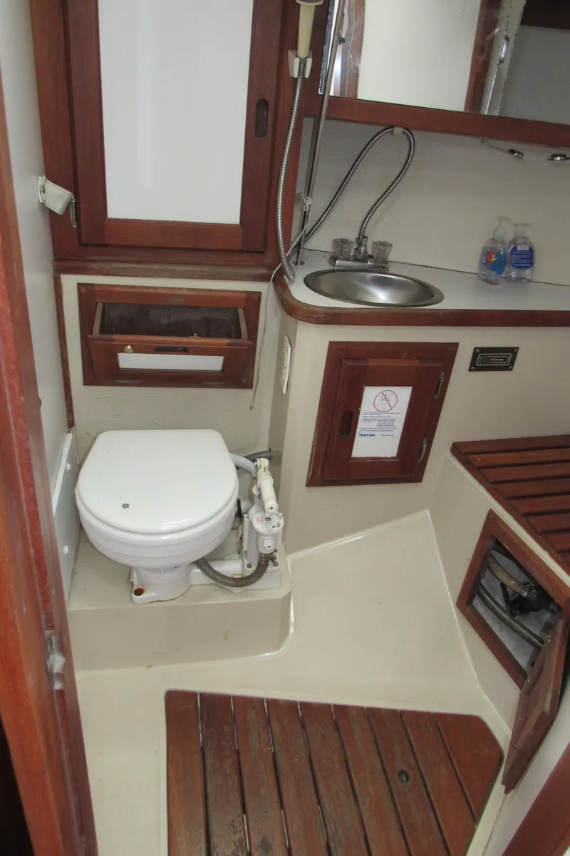 Slide: The Image of 1986 Catalina 36 yacht bathroom with toilet, sink, and wooden accents. - 12