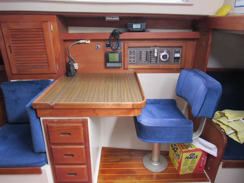 Slide: The Image of Interior of a 1986 Catalina 36 sailboat with navigation station and blue seating. - 8