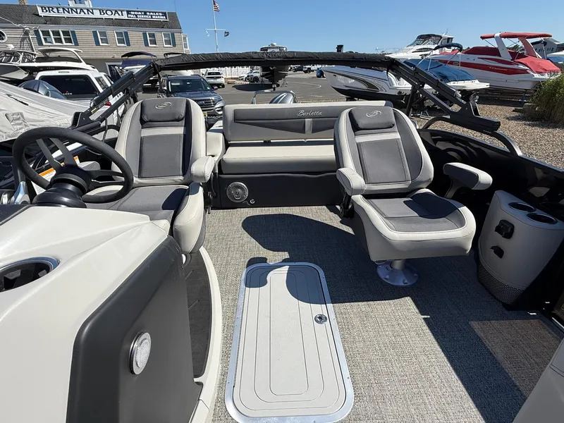 Slide: The Image of 2025 Barletta C22UC pontoon boat interior with gray seating and steering wheel. - 10