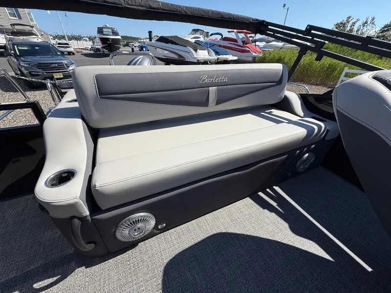 Slide: The Image of 2025 Barletta C22UC boat interior with cushioned seating and cup holders. - 12