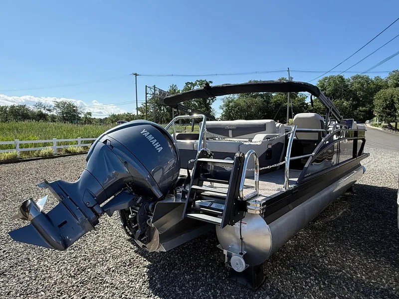 Slide: The Image of 2025 Barletta C22UC pontoon boat with Yamaha outboard motor, parked on gravel. - 16