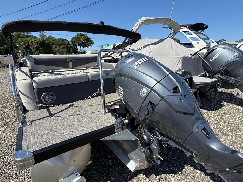 Slide: The Image of 2025 Barletta C22UC pontoon boat with Yamaha 200 engine, displayed outdoors. - 18