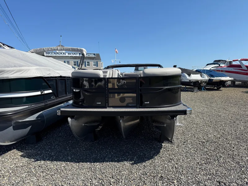 Slide: The Image of 2025 Barletta C22UC pontoon boat displayed at a dealership under clear blue skies. - 3