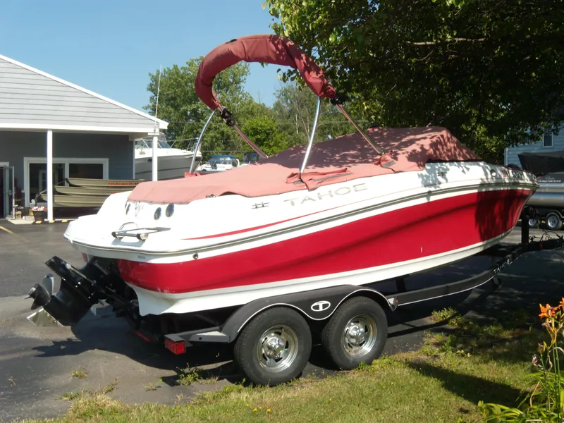 Slide: The Image of 2018 Tahoe 500 TS boat on trailer, red and white, parked outdoors. - 2