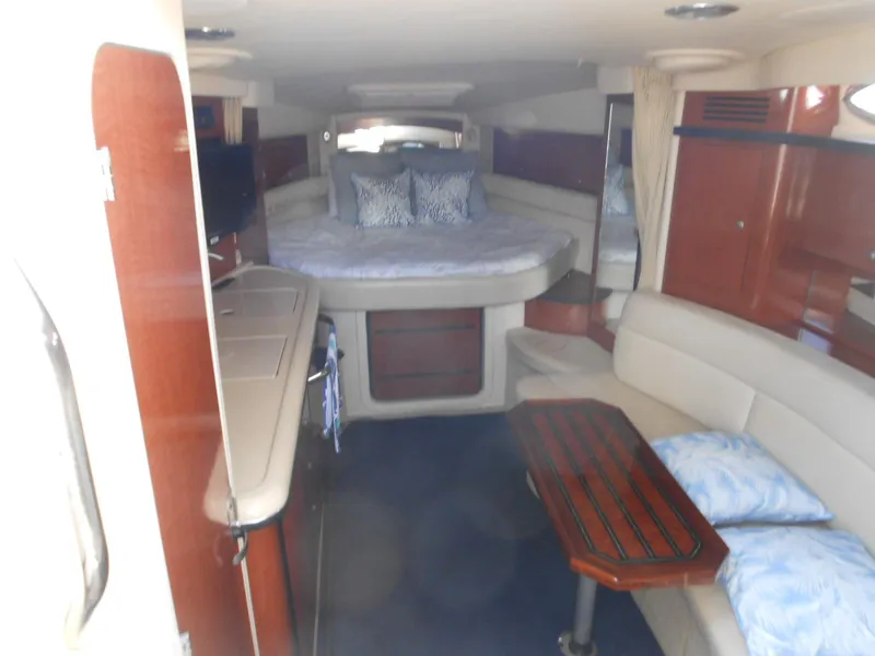Slide: The Image of 2005 Sea Ray 340 Sundancer interior with bed, seating, and wooden table. - 10