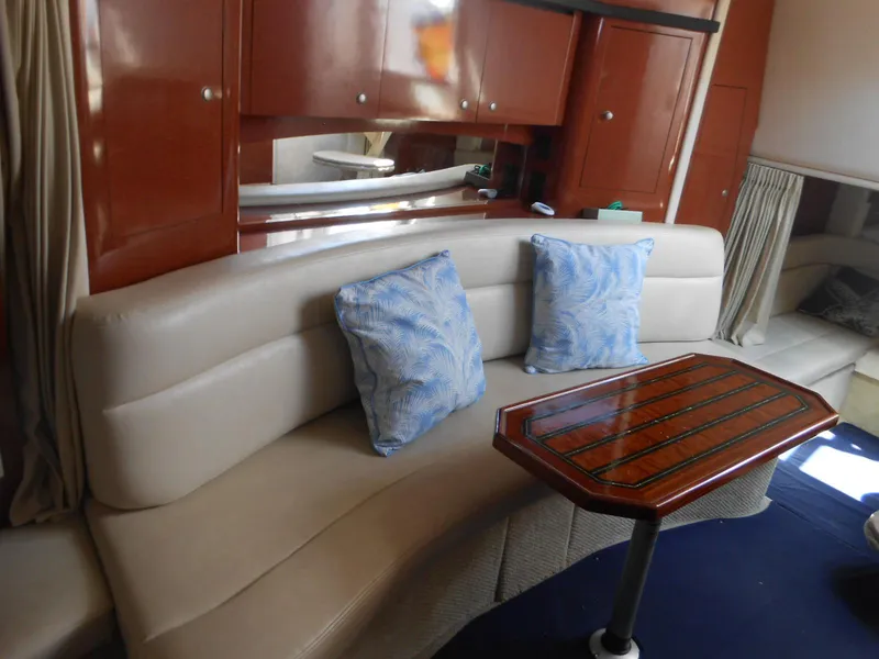 Slide: The Image of Interior of 2005 Sea Ray 340 Sundancer with beige seating and wooden table. - 12