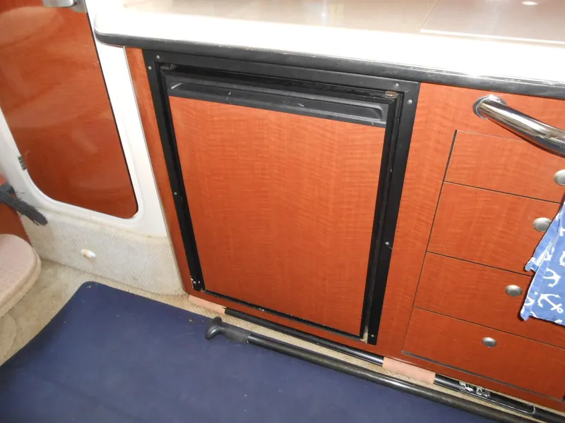 Slide: The Image of 2005 Sea Ray 340 Sundancer interior with wood cabinetry and compact refrigerator. - 19