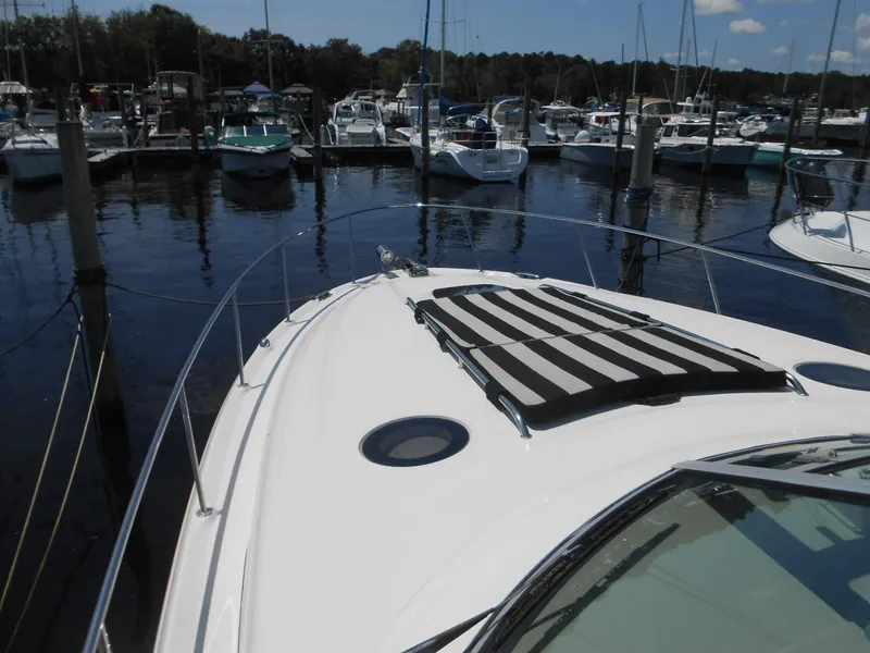 Slide: The Image of 2005 Sea Ray 340 Sundancer yacht docked at marina, featuring striped sun pad. - 27