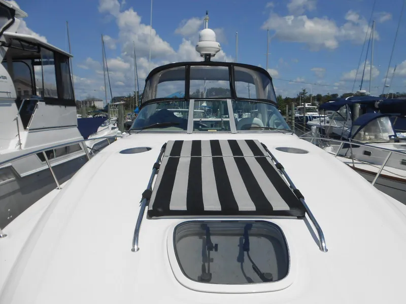 Slide: The Image of 2005 Sea Ray 340 Sundancer yacht with striped sun pad, docked under blue sky. - 30