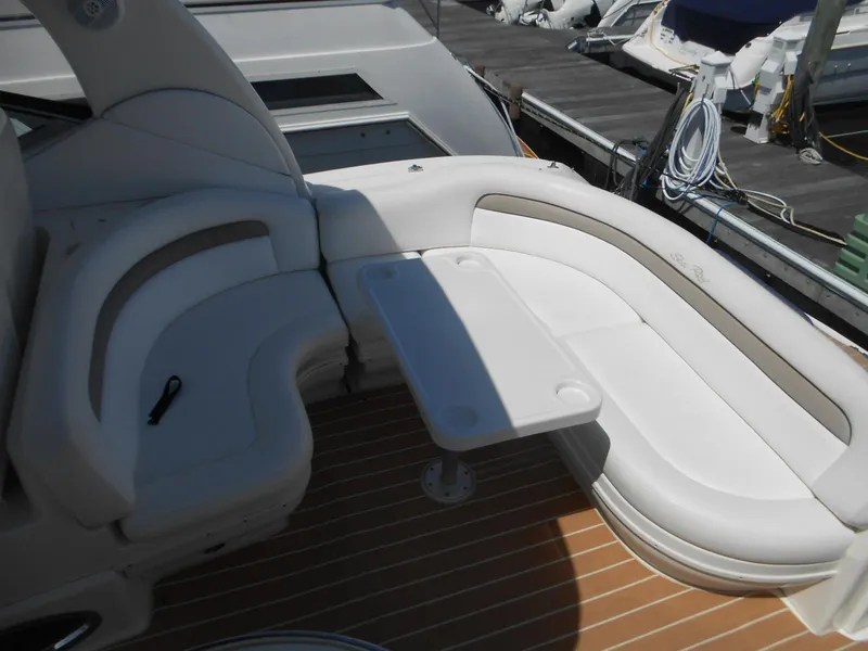 Slide: The Image of 2005 Sea Ray 340 Sundancer cockpit with white seating and table, docked at marina. - 32
