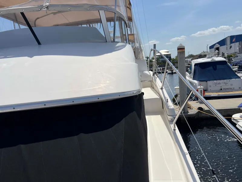 Slide: The Image of 2005 Silverton 38 Sport Bridge yacht docked at marina under clear sky. - 12