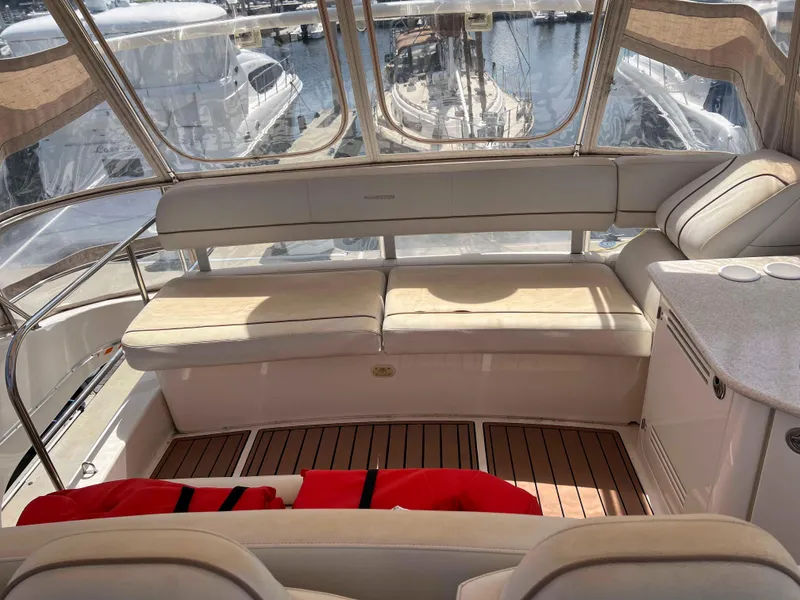 Slide: The Image of 2005 Silverton 38 Sport Bridge interior with seating, docked at marina. - 17