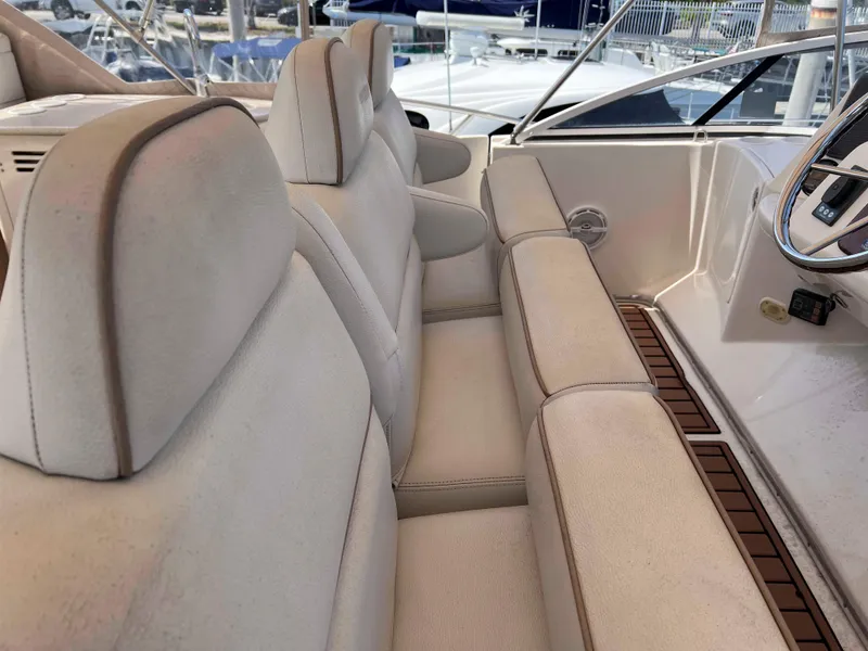 Slide: The Image of 2005 Silverton 38 Sport Bridge interior seating with beige upholstery and wooden accents. - 19