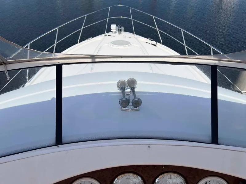 Slide: The Image of 2005 Silverton 38 Sport Bridge yacht bow view with clear railing and water backdrop. - 20