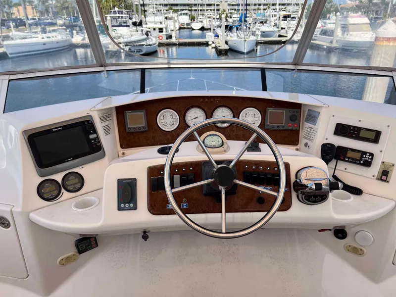 Slide: The Image of 2005 Silverton 38 Sport Bridge helm with steering wheel, gauges, and navigation equipment. - 29