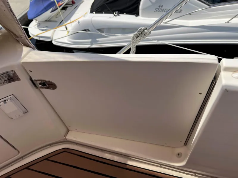 Slide: The Image of 2005 Silverton 38 Sport Bridge boat deck with open hatch, docked near another vessel. - 30
