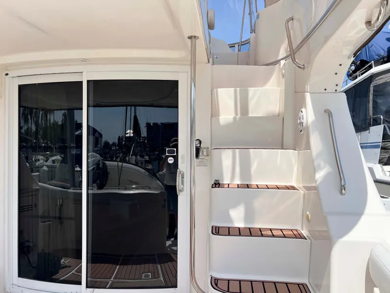 Slide: The Image of 2005 Silverton 38 Sport Bridge yacht with sliding glass door and staircase, docked at marina. - 37