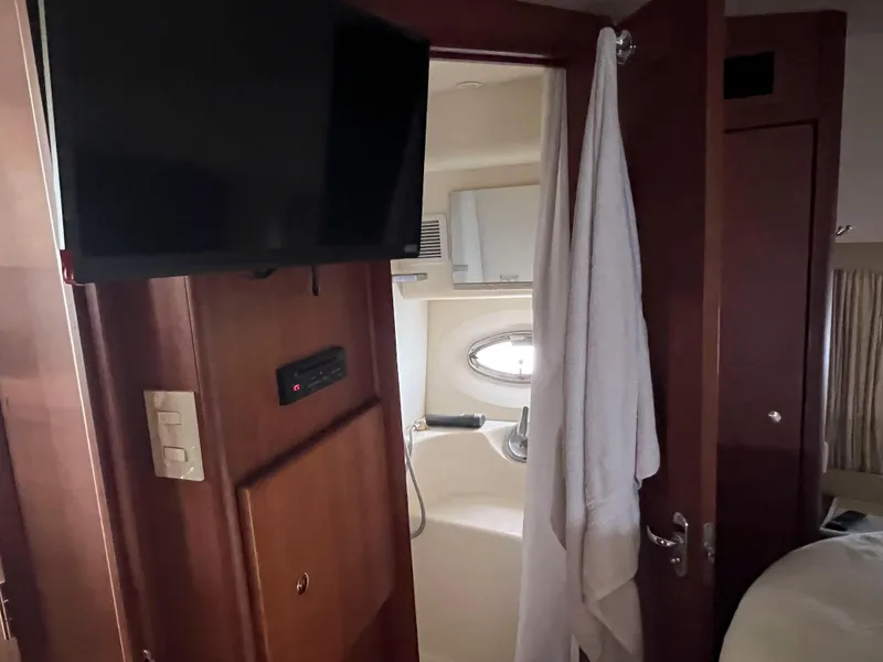 Slide: The Image of Interior of 2005 Silverton 38 Sport Bridge yacht, featuring a bathroom and mounted TV. - 45