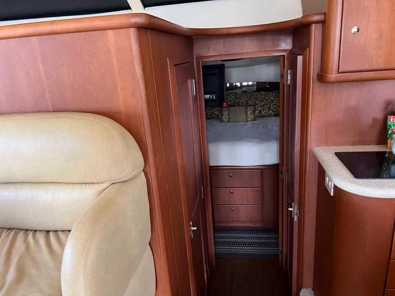 Slide: The Image of Interior of 2005 Silverton 38 Sport Bridge yacht with wood cabinetry and cozy bedroom. - 49