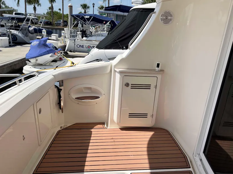 Slide: The Image of 2005 Silverton 38 Sport Bridge yacht deck with wood flooring and storage compartments. - 5