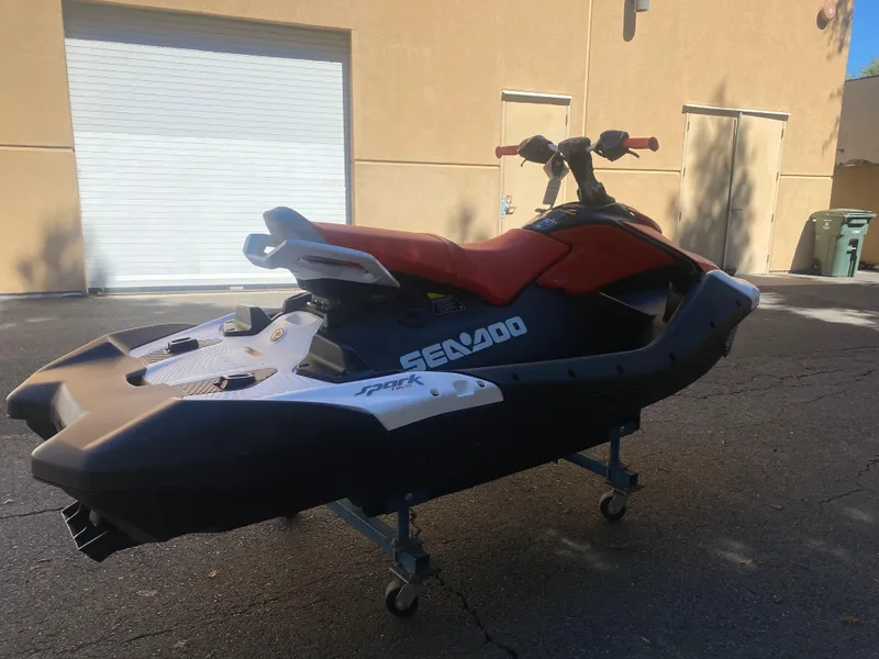 Slide: The Image of 2025 Sea-Doo SPARK TRIXX 3up jet ski parked outdoors on a sunny day. - 4