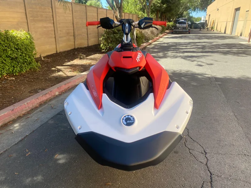 Slide: The Image of 2025 Sea-Doo SPARK TRIXX 3up jet ski parked on a sunny street. - 6