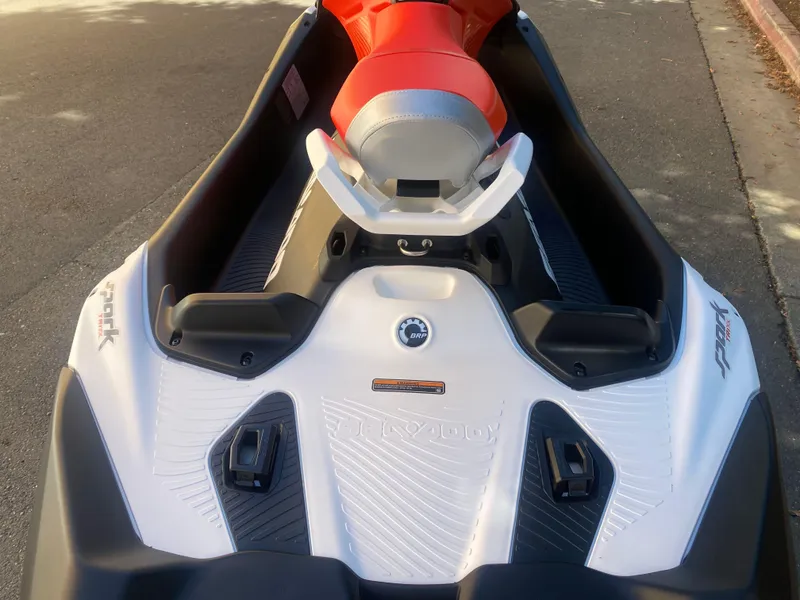 Slide: The Image of 2025 Sea-Doo SPARK TRIXX 3up jet ski with red seat, parked on pavement. - 8