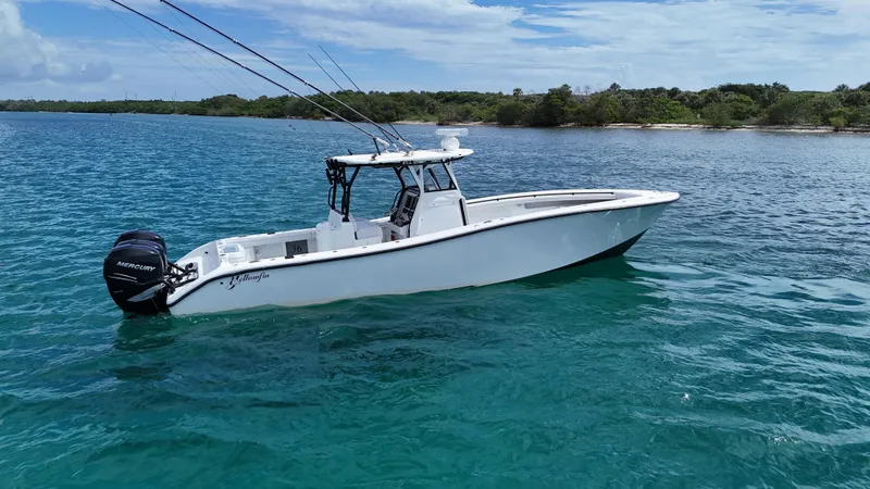 Slide: The Image of 2017 Yellowfin 36 Offshore boat on clear blue water near a lush shoreline. - 2